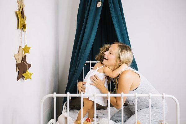 mother-hugging-baby-bed