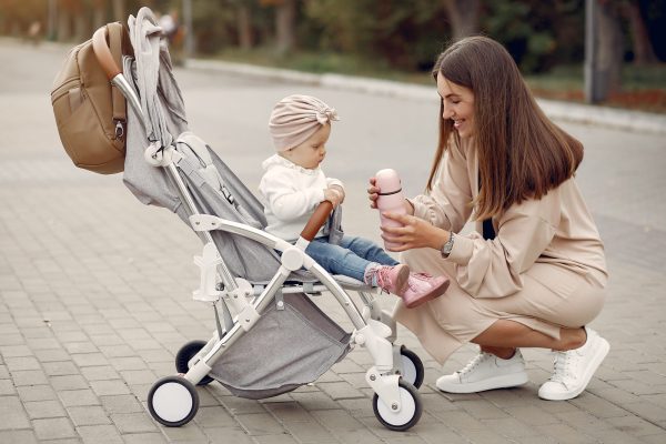 Mother with son. Woman use the carriages. Family in a autumn city